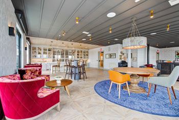 A lobby with chairs and tables and a reception area